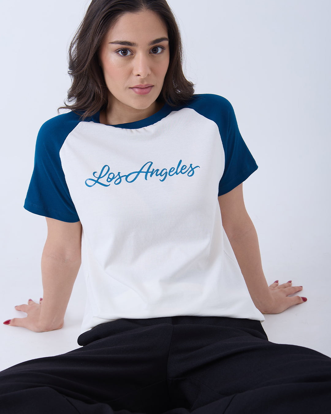 Los Angeles Raglan T-Shirt – white body with blue raglan sleeves and blue Los Angeles script on the chest, worn by model