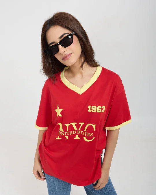 1963 Tap-Out V-Neck Oversize T-Shirt – red oversized DKY tee with yellow trim and gold UNITED STATES print, worn by model