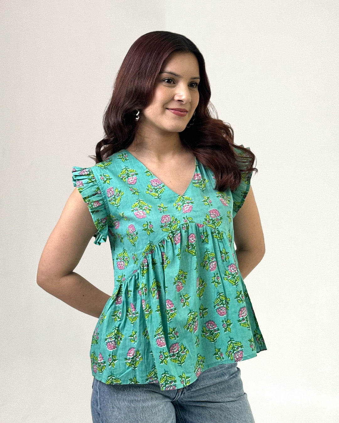 Green Cherry Peplum Top ā teal printed peplum top with pink floral print, worn by model