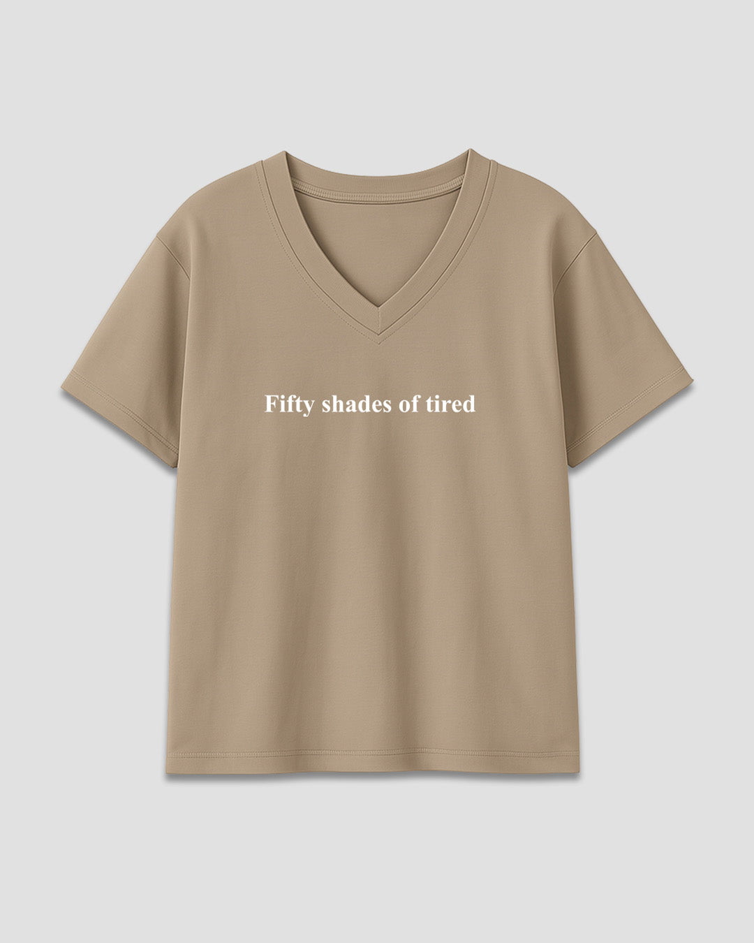 50 Shades Of Tired V-Neck Oversize T-Shirt ā beige oversized V-neck tee with white Fifty shades of tired text, shown in flat lay