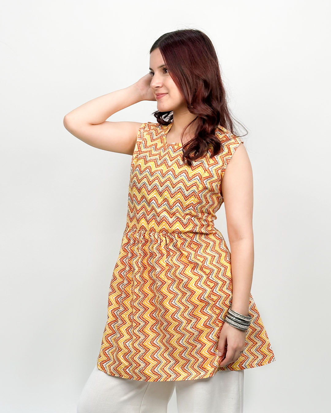Sunset Shuffle Cotton Top ā orange-yellow sleeveless A-line printed top with zigzag pattern, worn by model