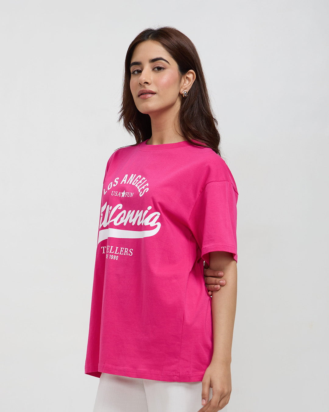 California Travellers Oversized T-Shirt – pink oversized graphic tee with white California print, worn by model