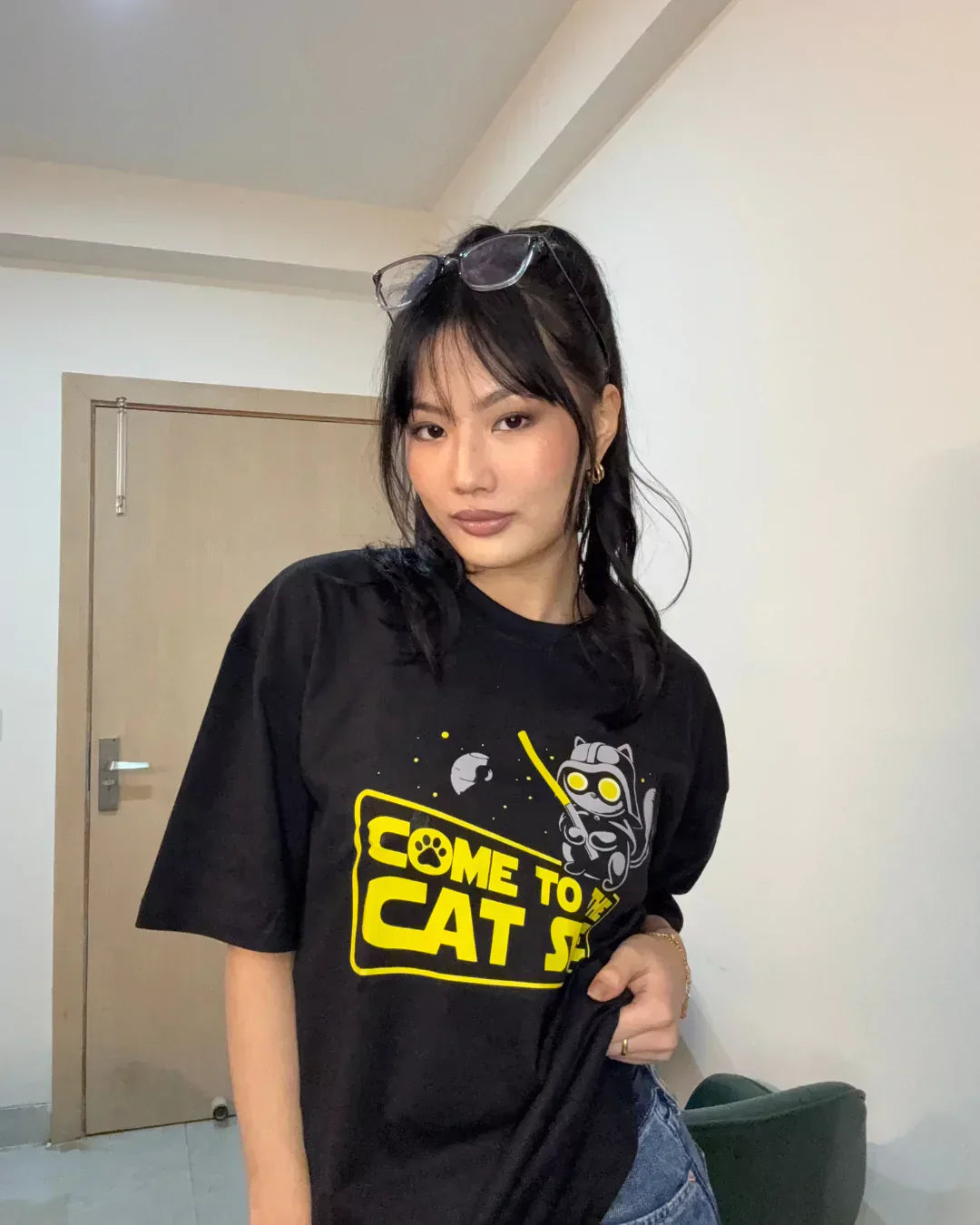 Cat Side Oversized T-shirt – black DKY graphic tee with a yellow cat graphic, worn by model.