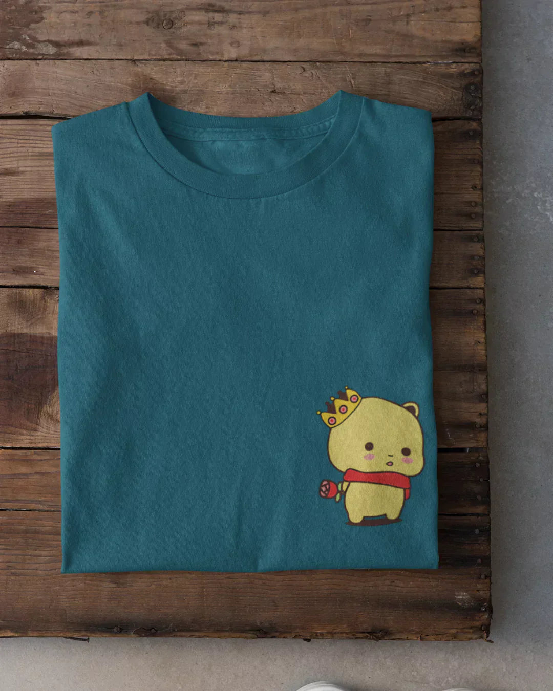 Cute King T-Shirt โ teal regular tee with a yellow crowned bear wearing a red scarf, shown in flat lay.