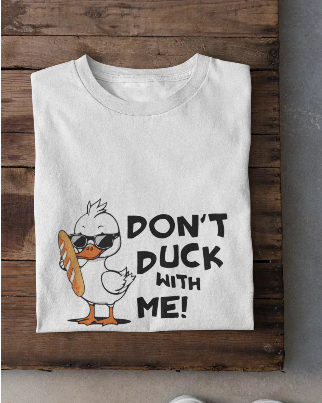 Don't Duck With Me T-Shirt - white graphic tee with a cartoon duck wearing sunglasses and a baguette, flat lay