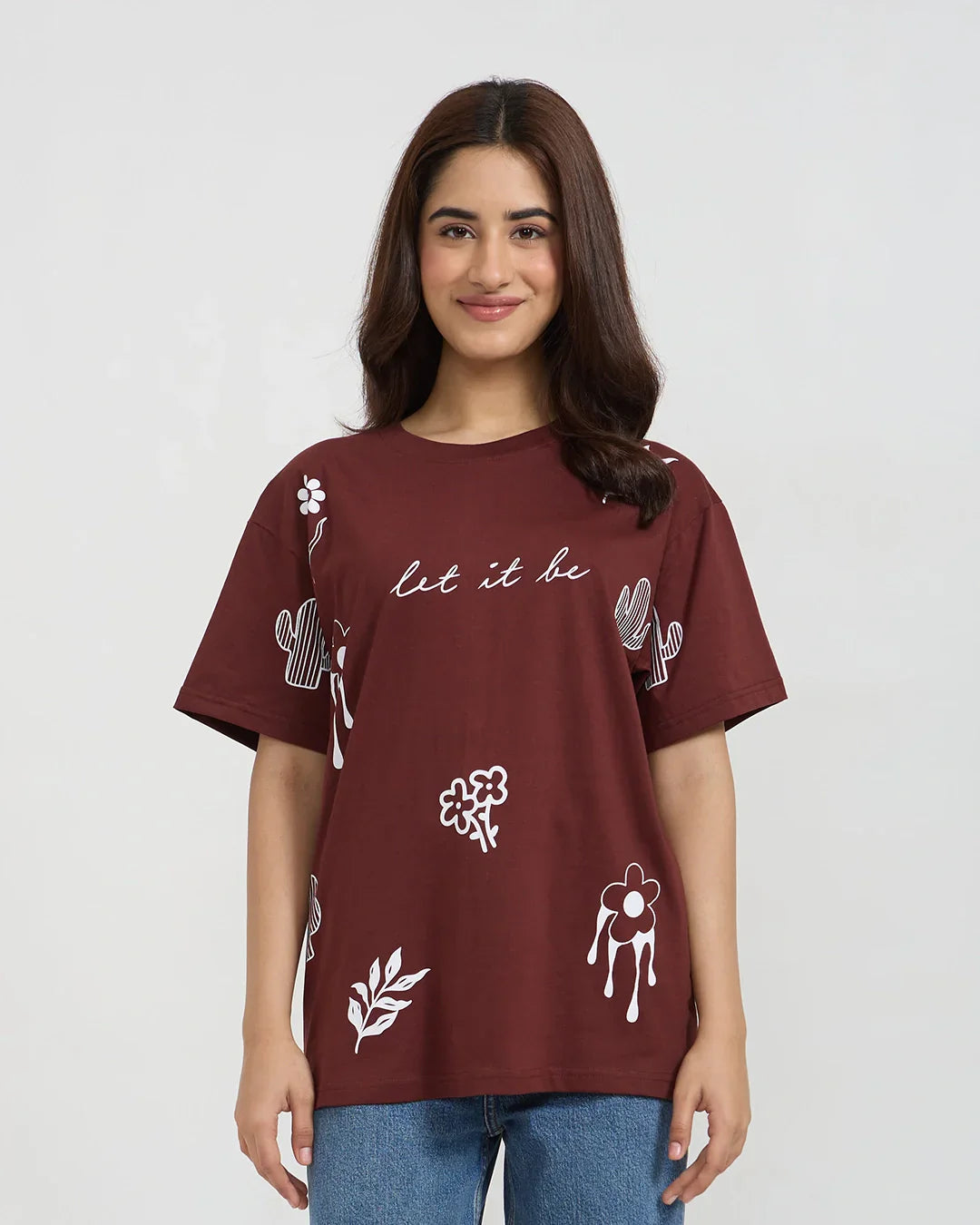 Let It Be Oversized T-Shirt – burgundy top with white floral prints and let it be script, worn by a model