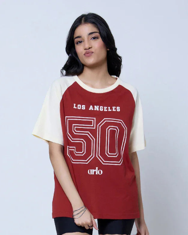 Los Angeles Raglan Oversized T-Shirt – red body with cream raglan sleeves, oversized fit, large 50 graphic, worn by model