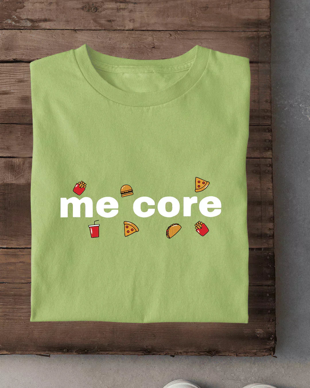 Me Core T-Shirt โ lime green regular tee graphic with white me core text and small food icons, shown in flat lay