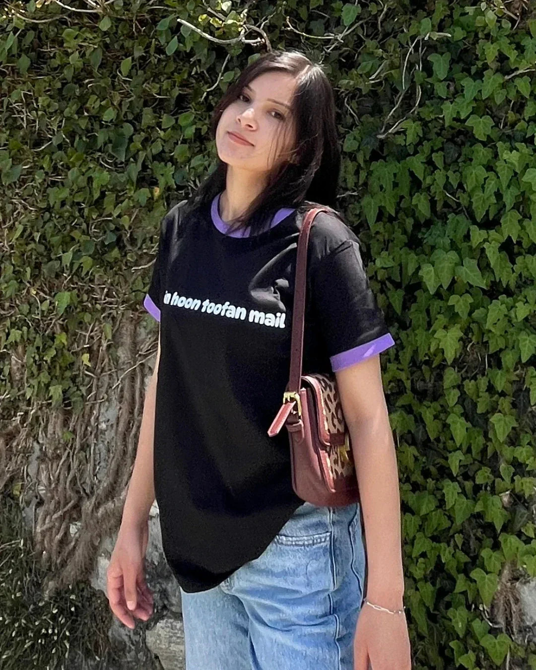 Mein Hoon Toofan Mail Tap Out T-Shirt – black regular tee with purple trim and white text, worn by model