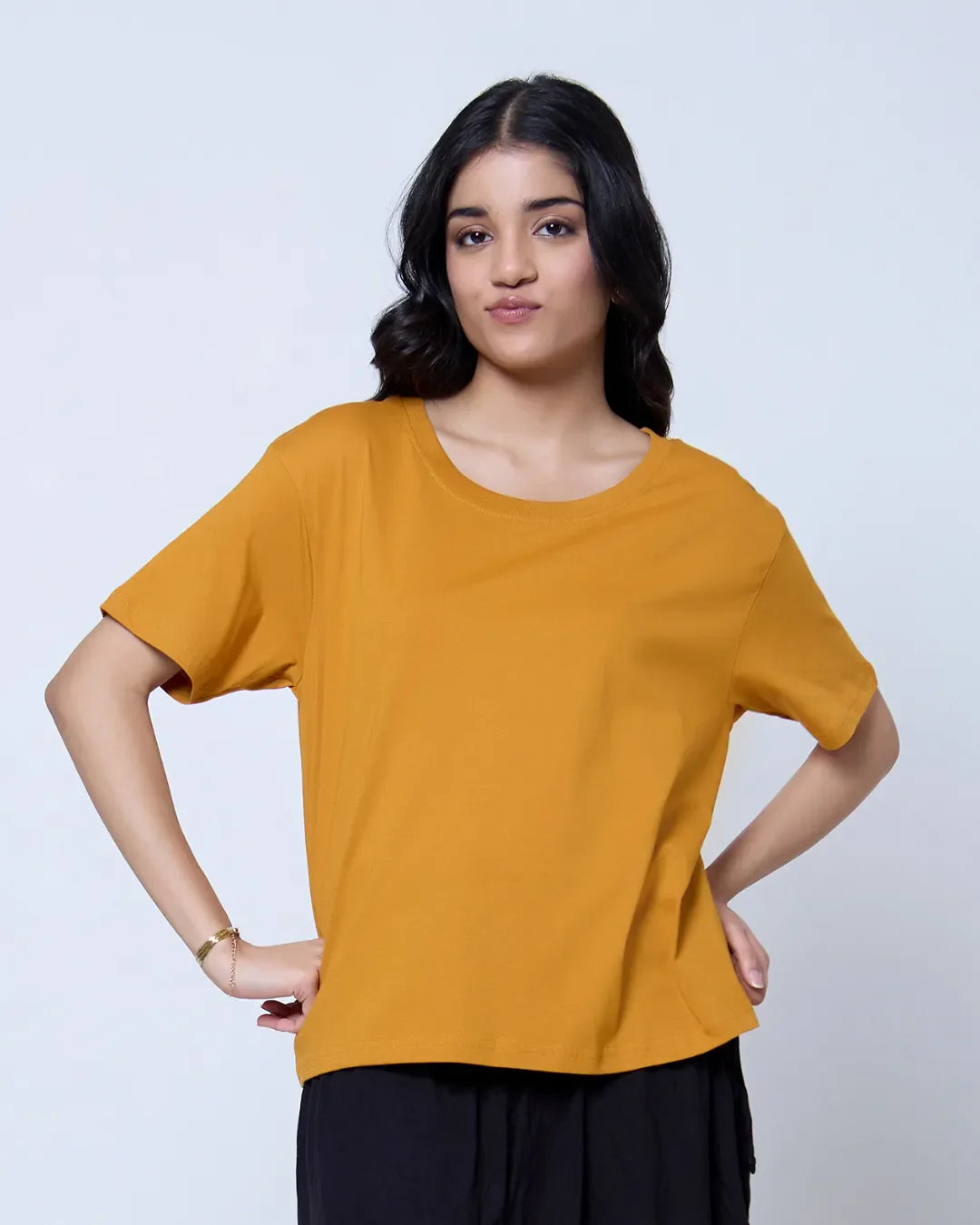 Mustard plain boxy oversize T-shirt worn by model; mustard color, relaxed fit, short sleeves, 100% pure fabric