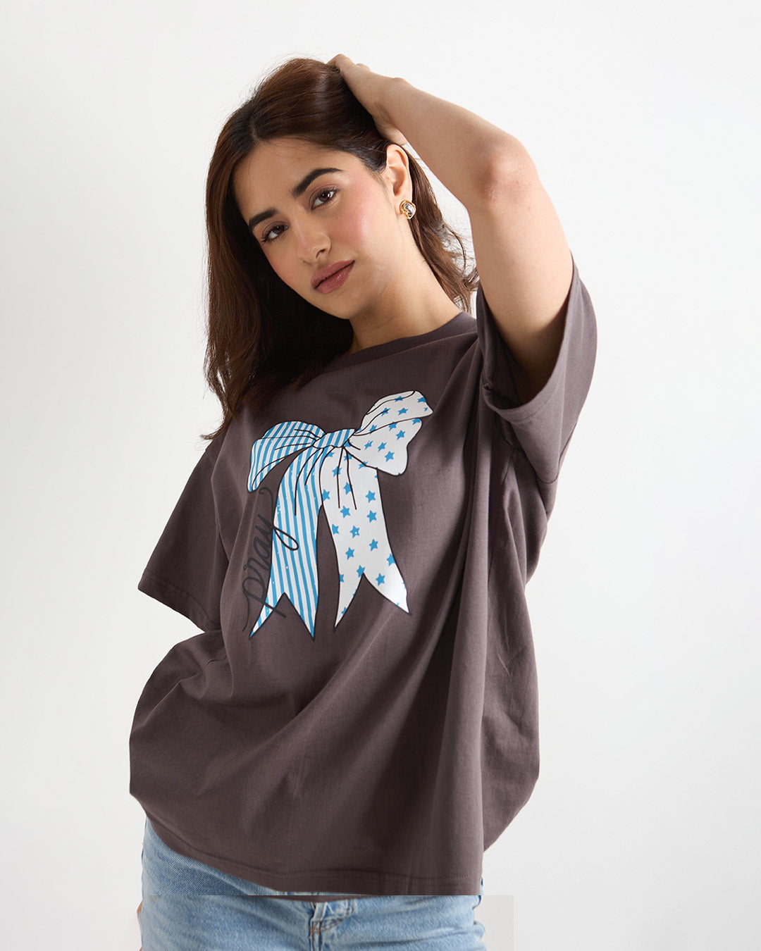 Pray Oversized T-shirt – charcoal gray oversized graphic tee with a blue star-striped bow graphic, worn by model