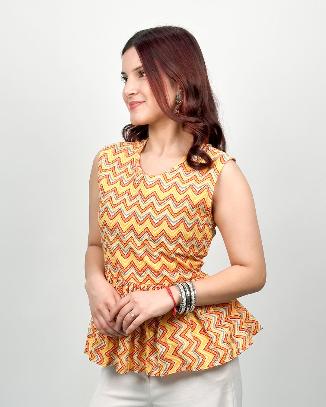 Tangerine Peplum Cotton Top ā orange-yellow zigzag print, peplum silhouette, worn by model