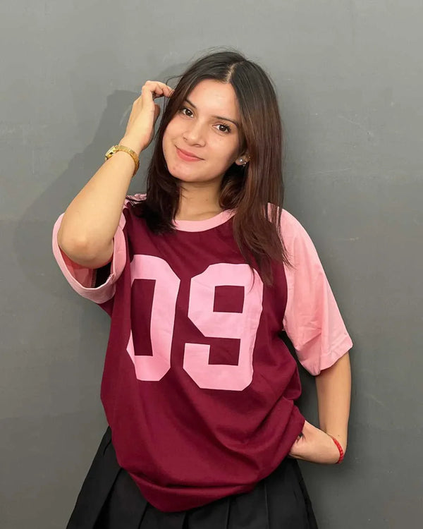 09 Raglan Oversized T-Shirt - maroon body with pink sleeves, oversized fit and pink 09 graphic on front, worn by model.