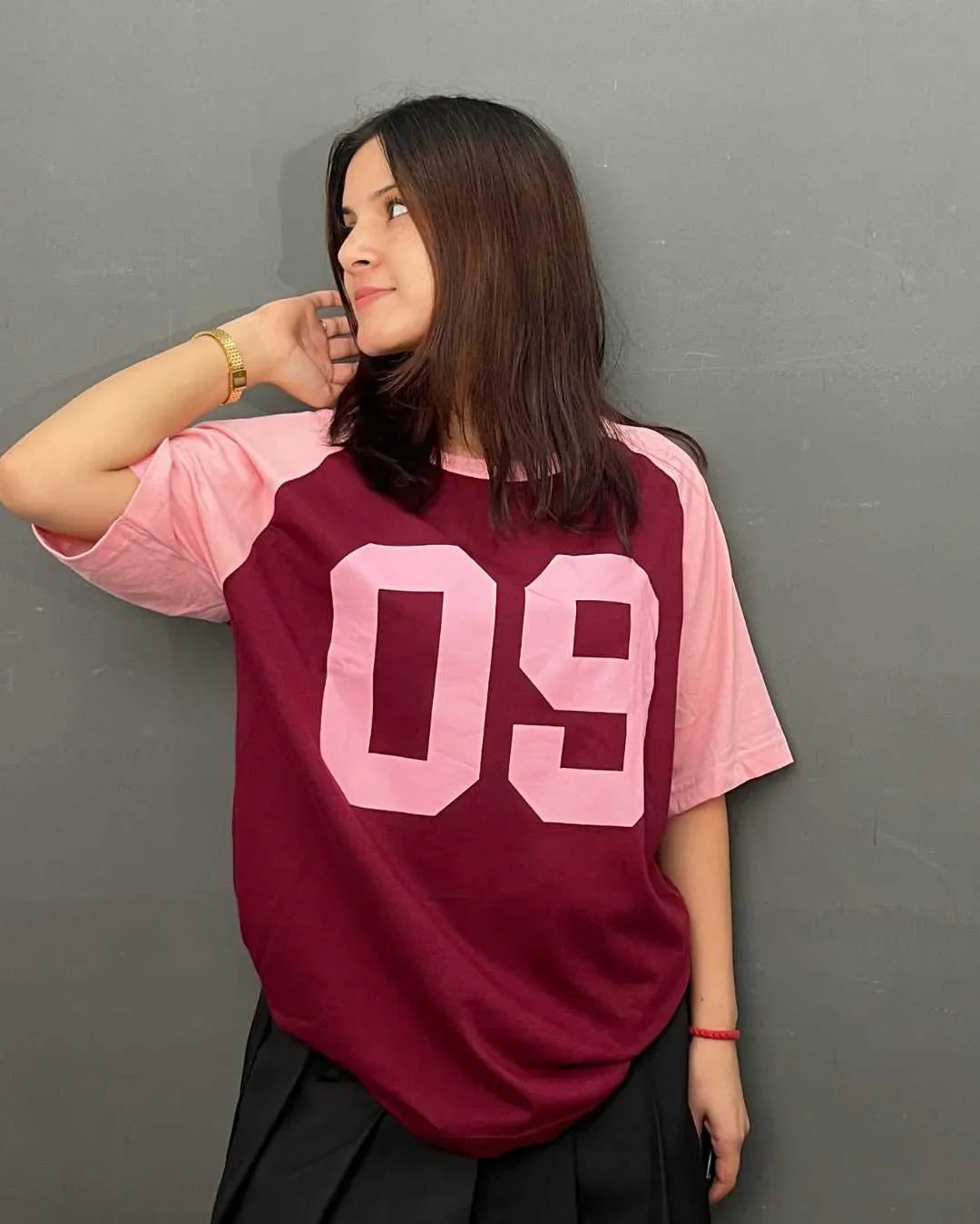 09 Raglan Oversized T-Shirt – maroon body with pink raglan sleeves and a large pink 09 graphic, worn by model