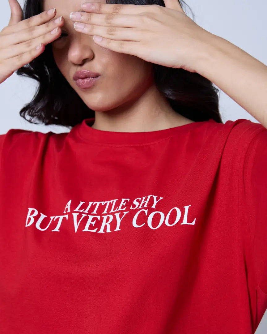 A Little Shy But Very Cool Oversized T-Shirt – red, oversized fit with white text graphic on chest, worn by model.