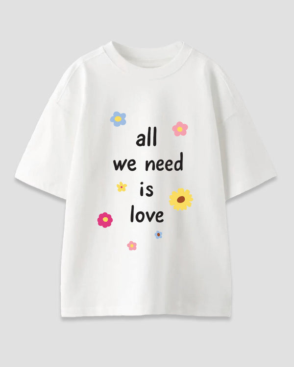 All We Need Is Love Oversized T-Shirt – white oversized graphic tee with colorful flowers and the phrase all we need is love, shown in flat lay