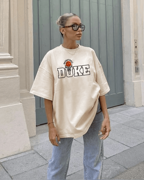Arlo Duke Oversized T-Shirt – beige graphic tee with DUKE basketball logo, worn by model