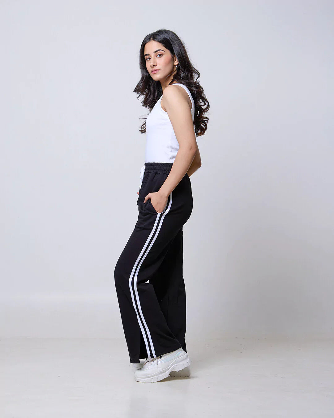 Black Gossip Pants – DKY BW jogpant in black with white side stripes, relaxed fit, worn by model