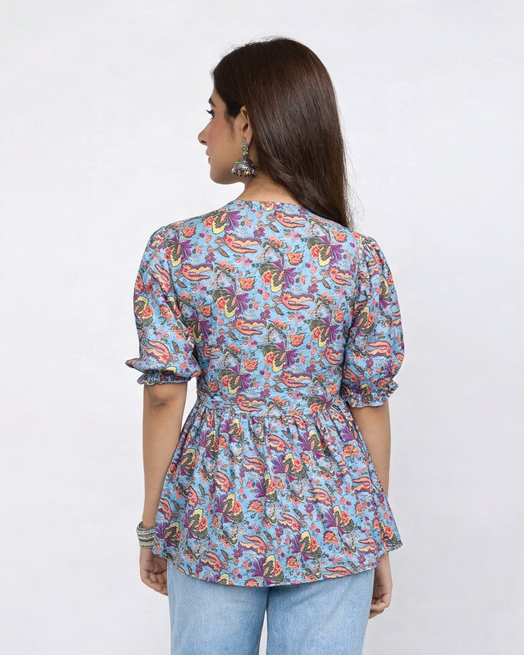 Blue Haze Cotton Top – blue printed cotton top with puff sleeves and peplum waist, worn by model (back view).