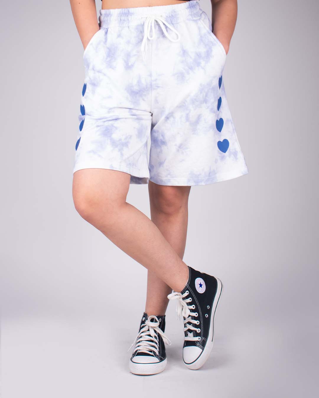 Blue Tie Dye Bermuda Shorts – blue tie-dye pattern, relaxed fit with blue heart side accents, by DKY, worn by model