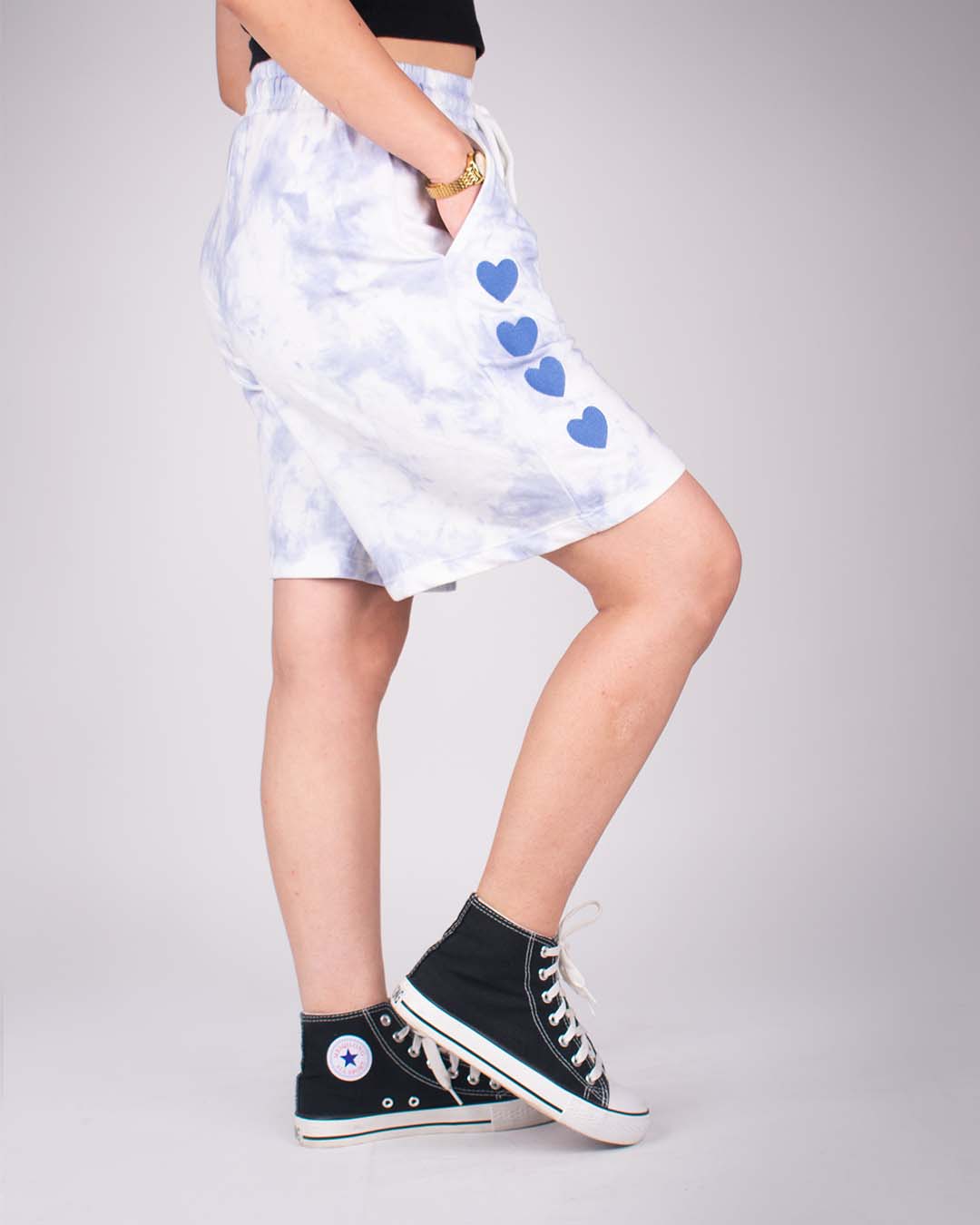 Blue Tie Dye Bermuda Shorts – blue and white tie-dye shorts with blue heart graphics down the side, worn by model