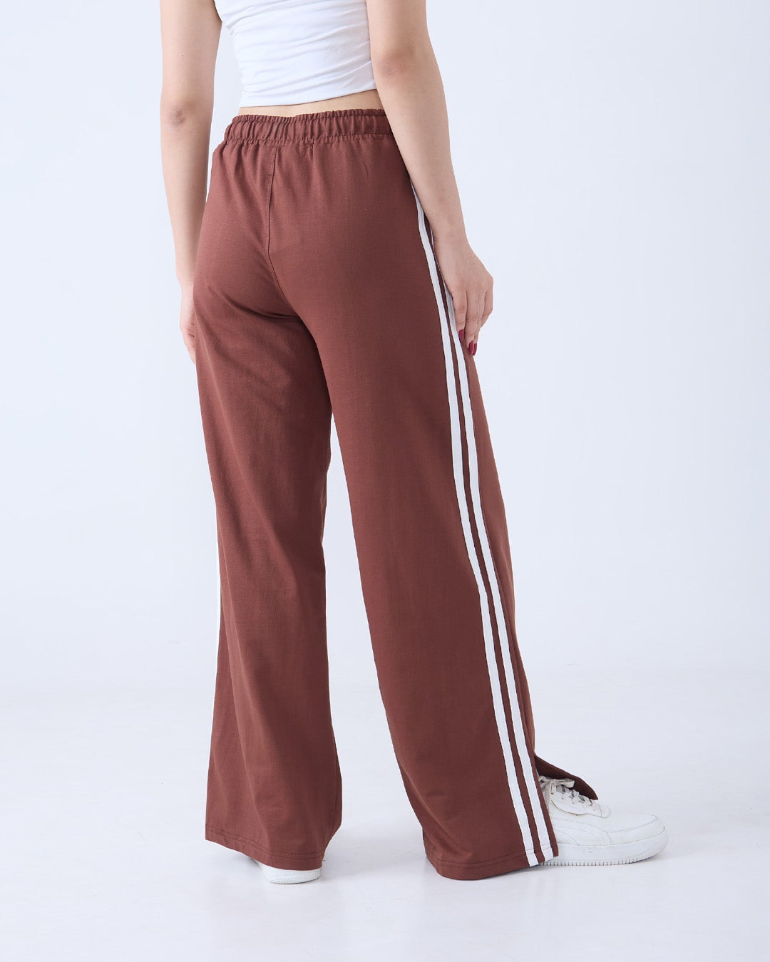 Brown Gossip Pants – jogpant with white side stripes, relaxed wide-leg fit, worn by model