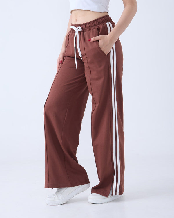 Brown Gossip Pants – brown wide-leg jogpant with white side stripes, worn by model.