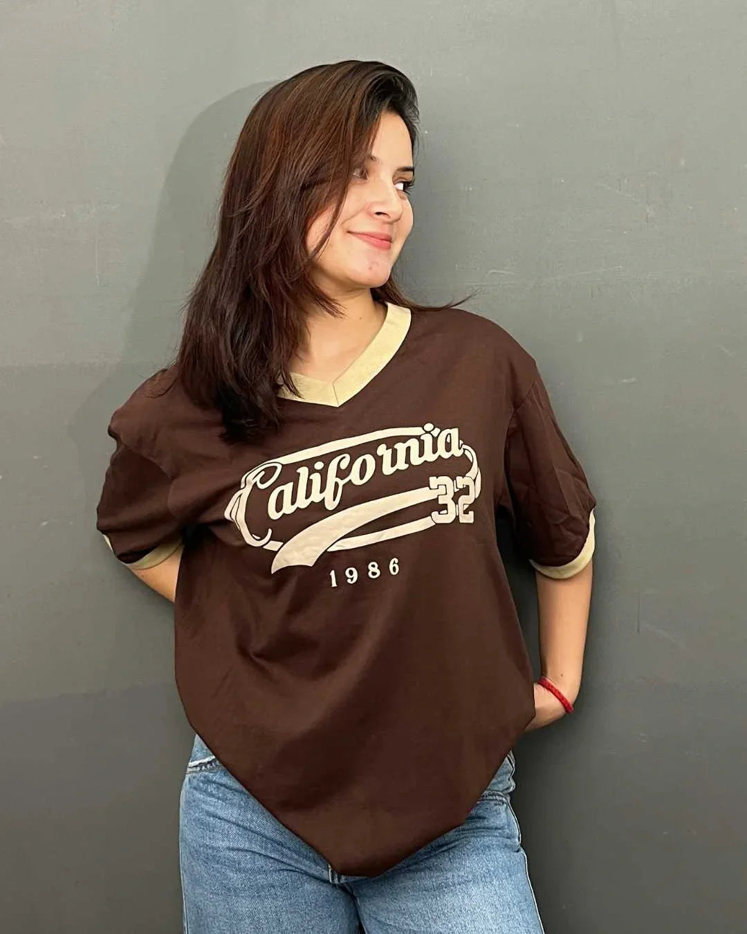 California Tap-Out V-Neck Oversize T-Shirt – brown oversized V-neck tee with cream California graphic, worn by model