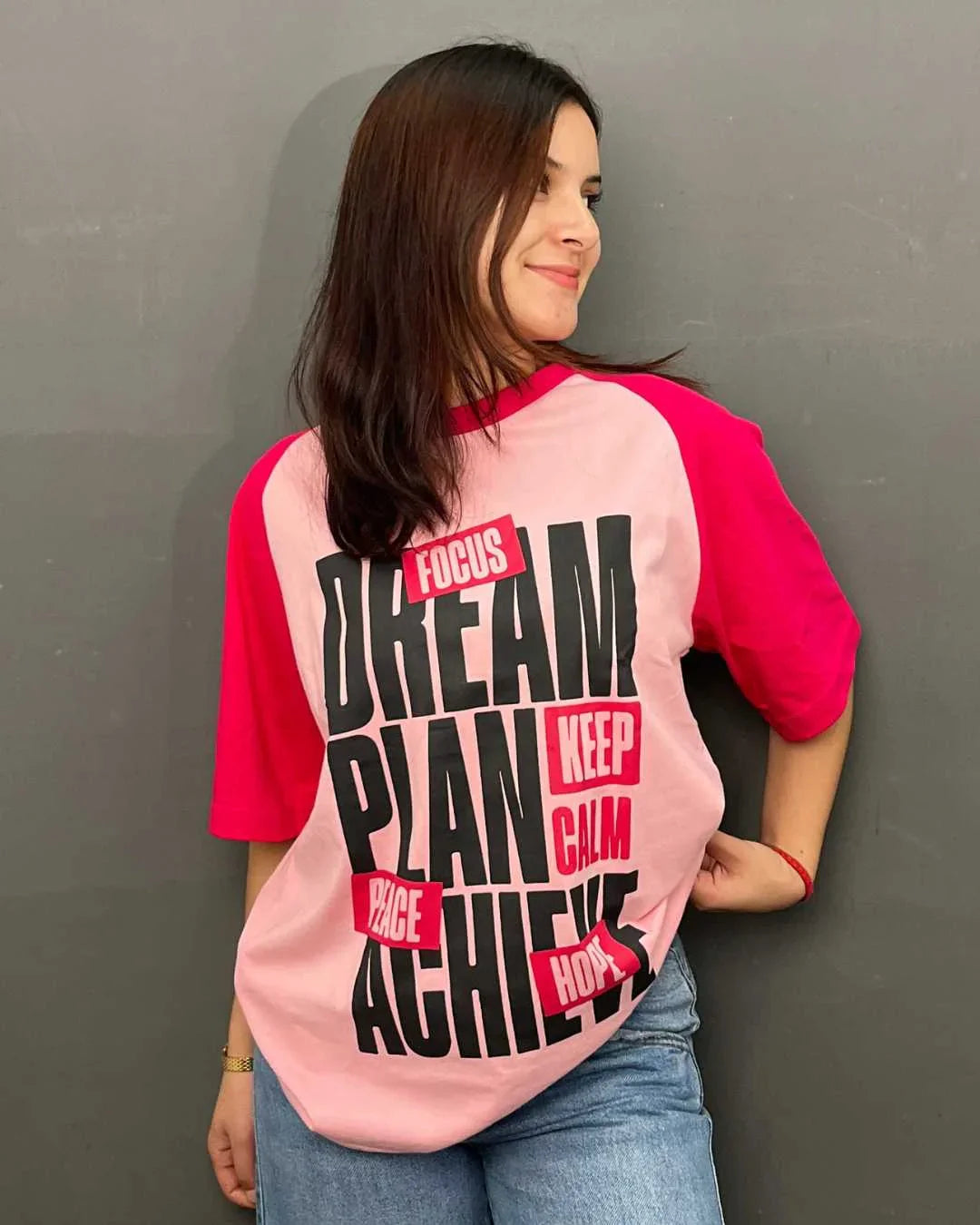 Dream Raglan Oversized T-Shirt – pink body with hot pink sleeves, bold black graphic text on back, worn by model