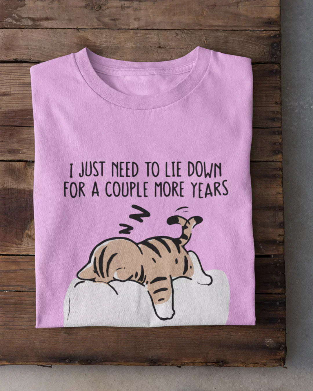 I Just Need To Lie Down T-Shirt by DKY - lavender pink tee with a lounging cat print, shown in flat lay