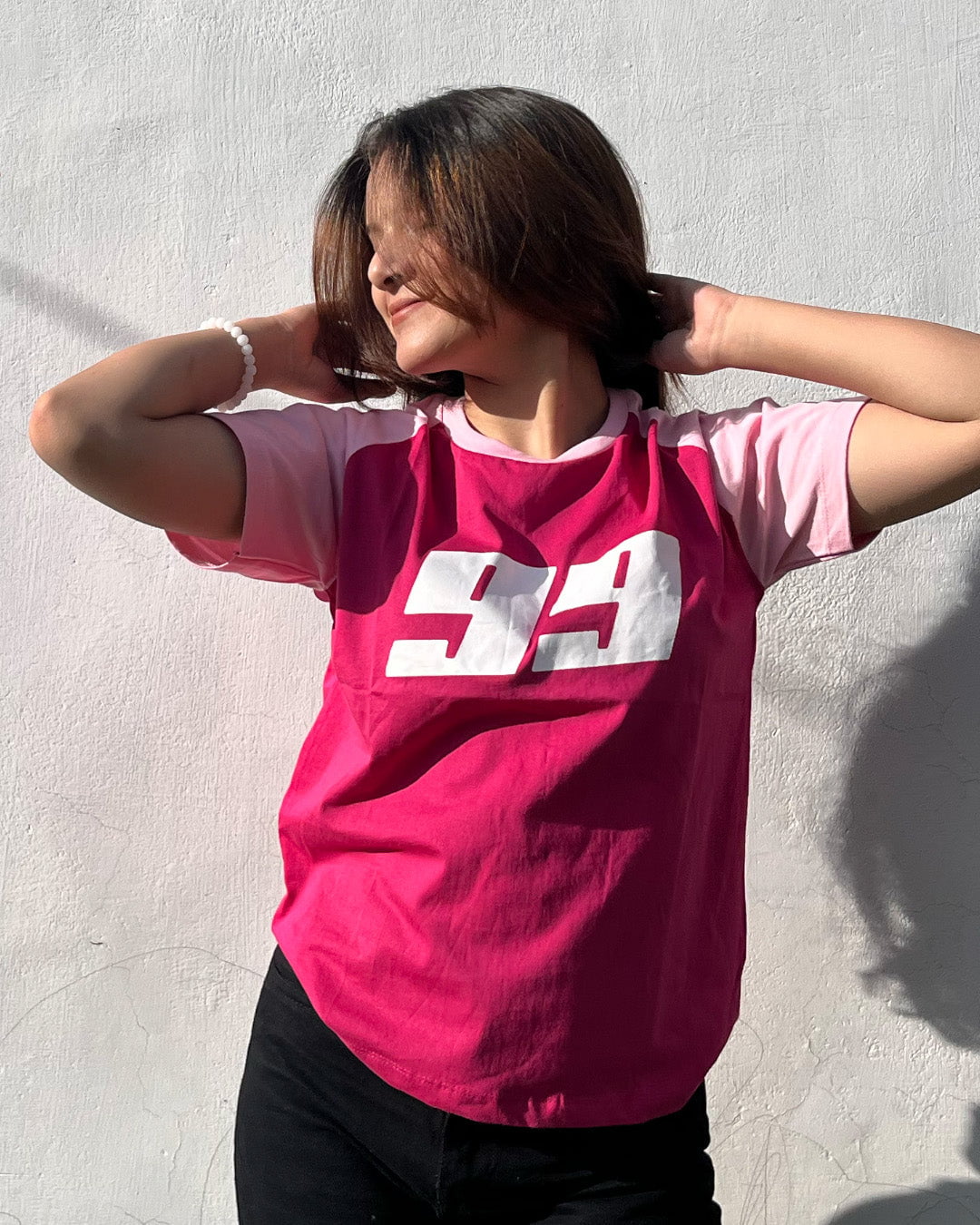 Pink 99 Raglan T-Shirt - pink body with light pink raglan sleeves and bold white 99 graphic, worn by model
