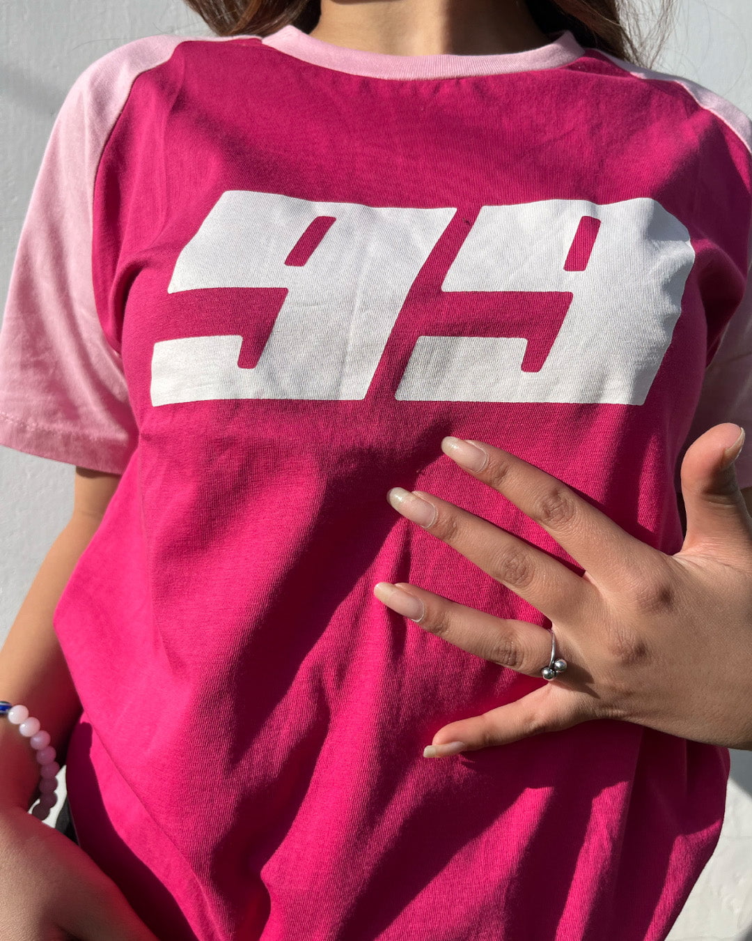Pink 99 Raglan T-Shirt magenta body with light pink raglan sleeves and bold white 99 graphic worn by model