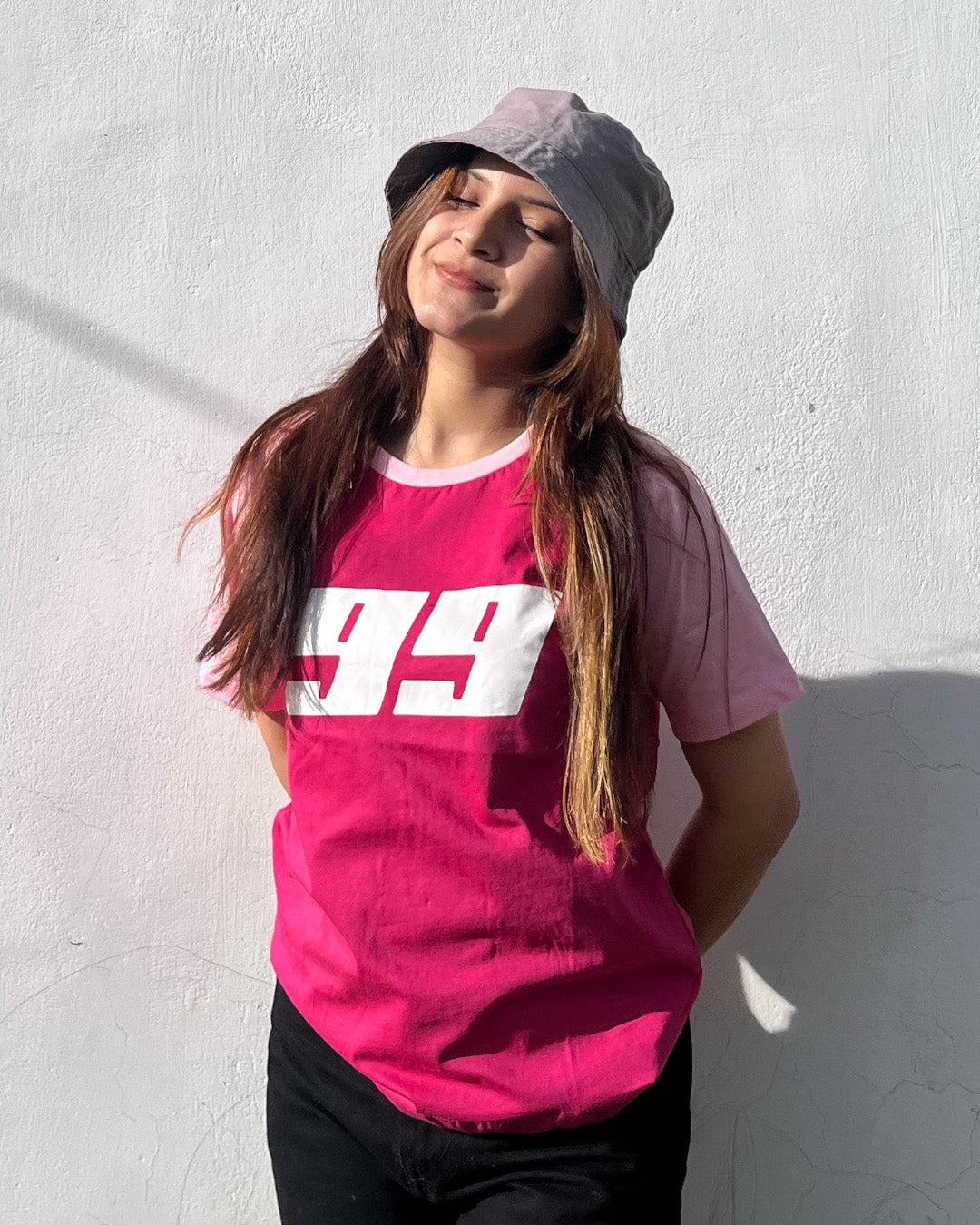 Pink 99 Raglan T‑Shirt – pink body with light pink raglan sleeves and white 99 graphic, worn by model