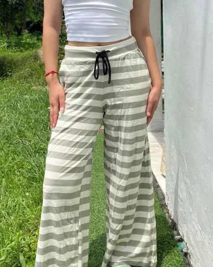 Sage Pajama – beige and white striped wide-leg pajama pants with a black drawstring, worn by model.