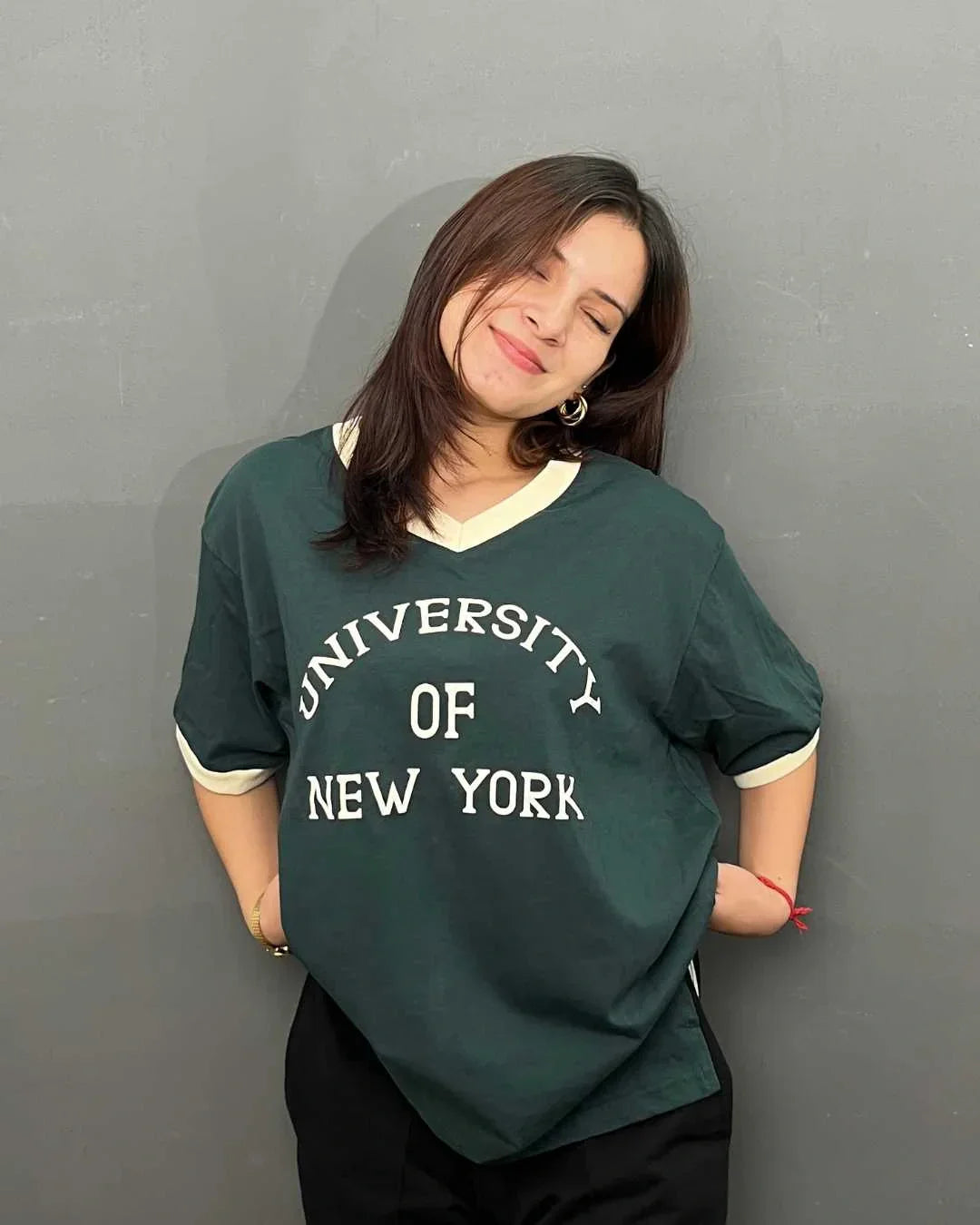 Uni NY Tap-Out V-Neck Oversize T-Shirt – dark green V-neck tee with University of New York graphic, worn by model