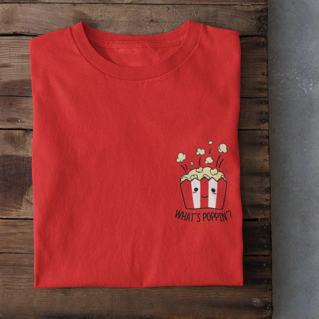 Whats Poppin T-Shirt – red regular tee with popcorn graphic and What's Poppin? text, flat lay